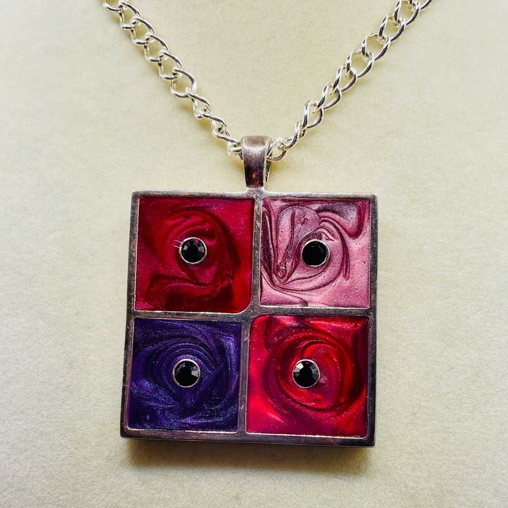 Red, purple, and pink square swirl enamel pendant with red crystals on a chain